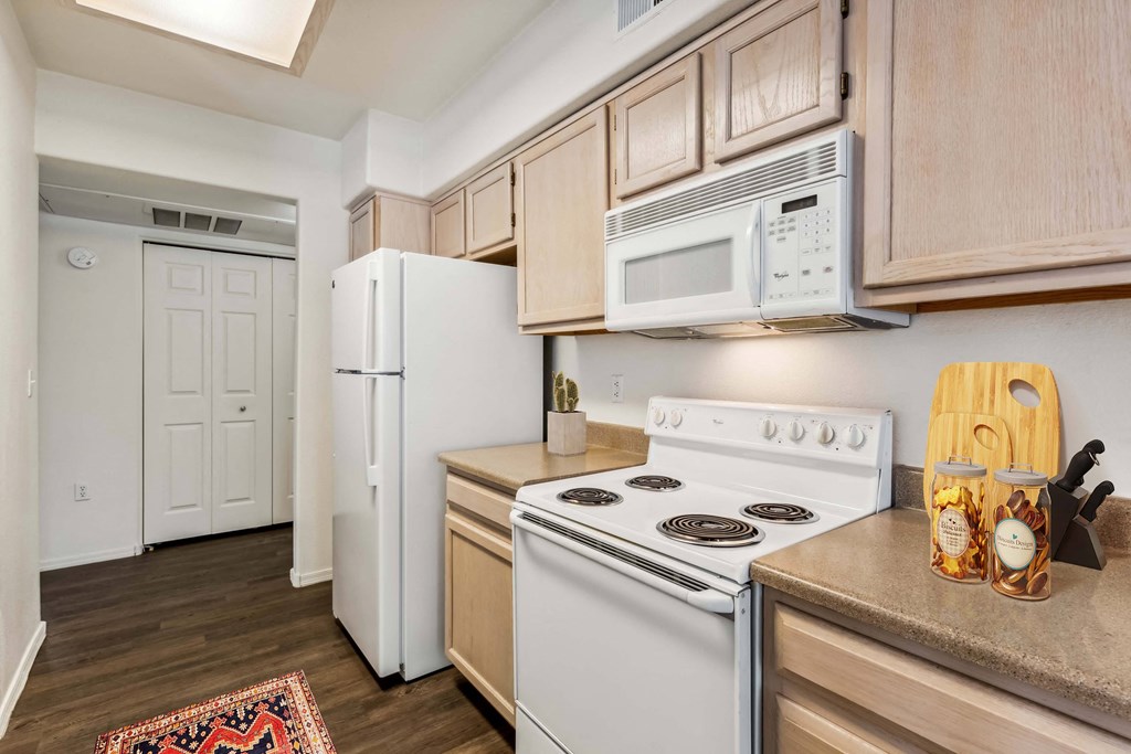 a kitchen with white appliances and wooden cabinets at Altezza High Desert, New Mexico